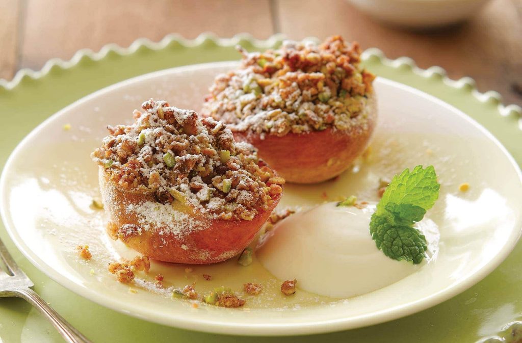 Grilled peaches with berry sauce and pistachio crumble topping
