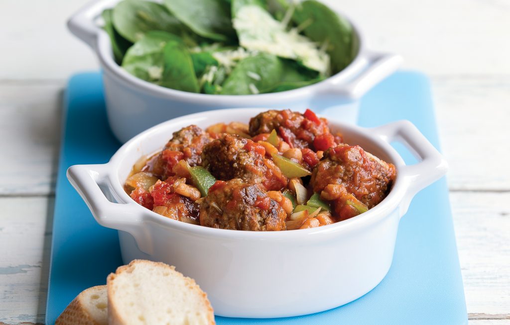 Mini meatballs in a baked bean sauce with leafy green salad and crusty bread