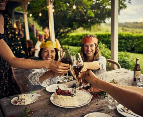 people toasting around a table on a porch