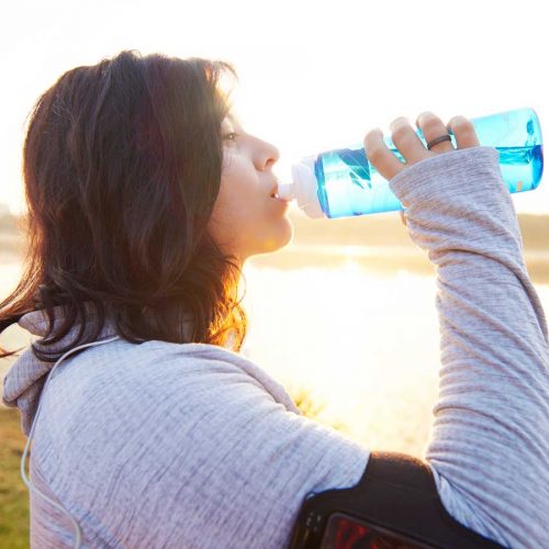 Woman drinking water after exercise