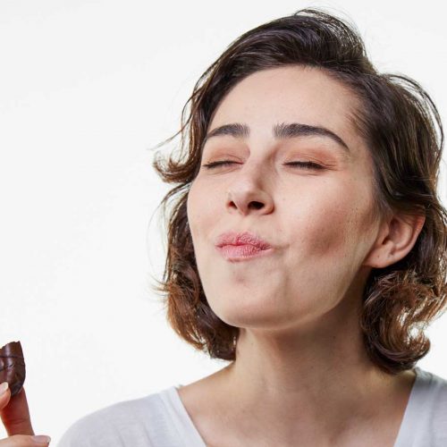 Woman eating a chocolate biscuit
