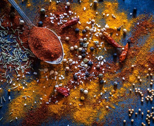 A tespoonful and scattering of different spices ground and whole