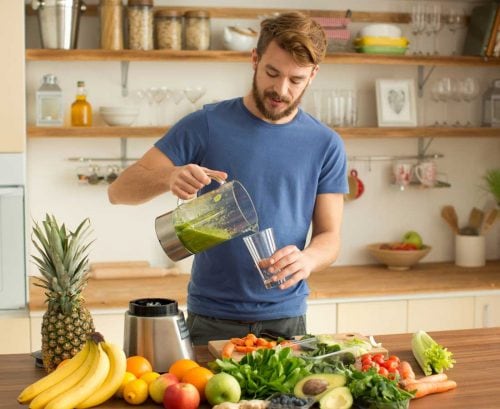 Man making a green smoothie to detox with