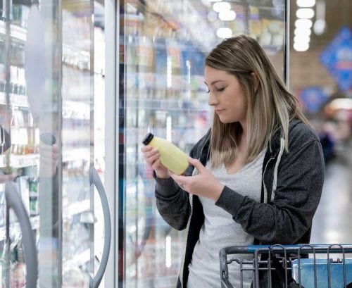 Woman reading food label at supermarket