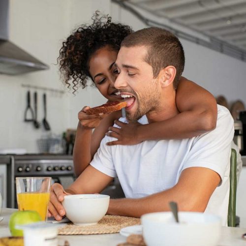 woman feeding wholegrain toast to her boyfriend
