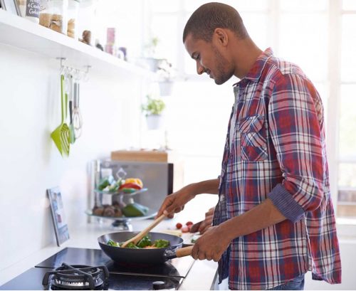 Man cooking vegetables in a pan
