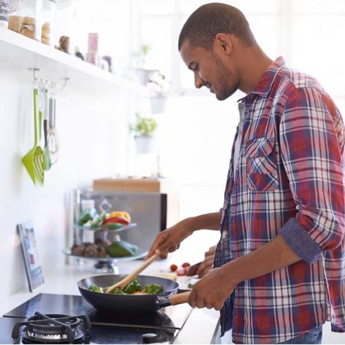 Man cooking vegetables in a pan