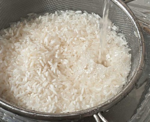 Rinsing white rice with water