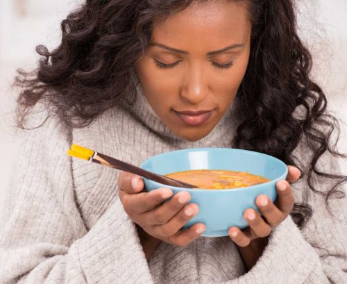 Woman smelling her soup