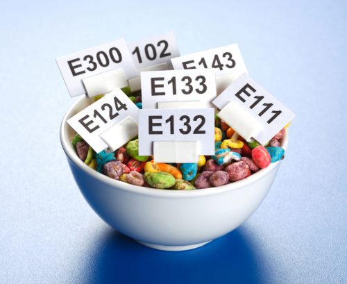 Bowlful of colourful cereal with E-name tags for various food additives