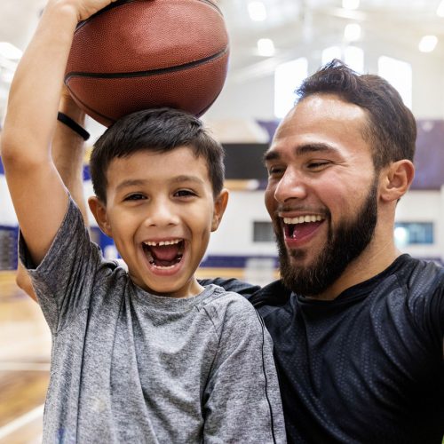 Happy father and son playing with a basketball