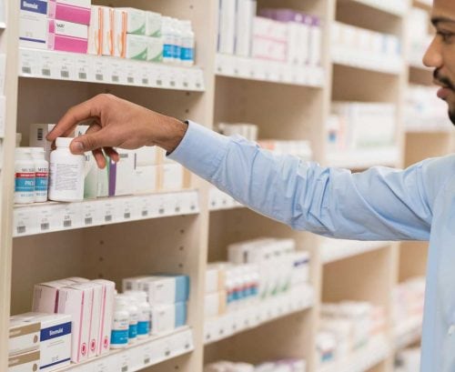 Man looking at probiotics on shelf in pharmacy