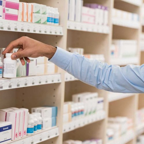 Man looking at probiotics on shelf in pharmacy