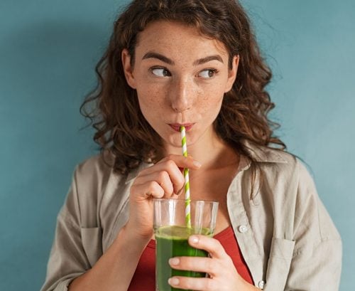 Woman drinking a green kale smoothie