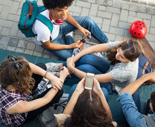 A group of teens sitting on the ground