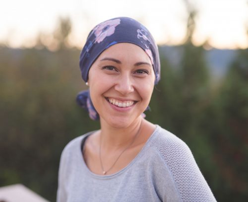 Woman with scarf on her head smiling at camera
