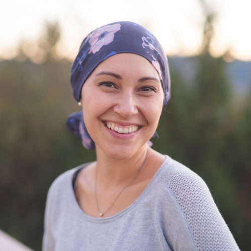 Woman with scarf on her head smiling at camera