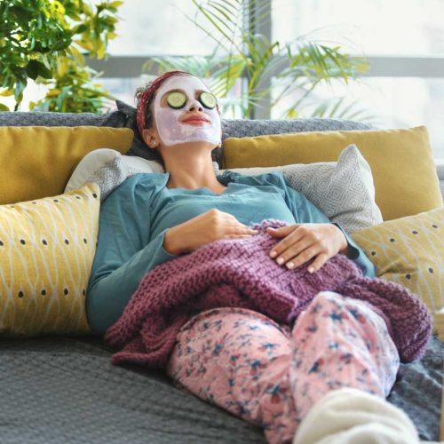 Woman lying on sofa with face mask on