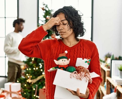 Woman with Christmas decorations with a headache