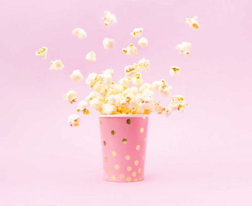 Popcorn exploding from a pink cup