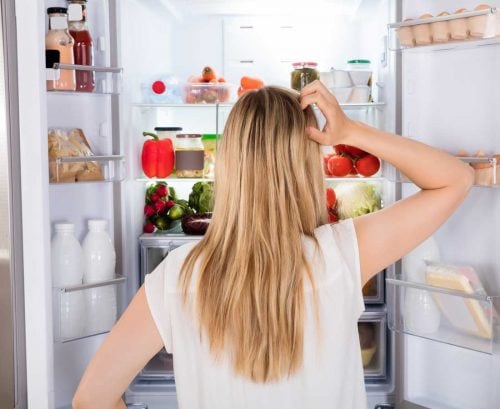 Woman staring into fridge