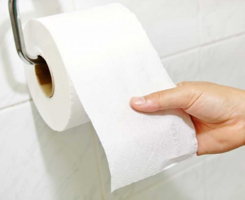 Hand reaching for toilet paper roll