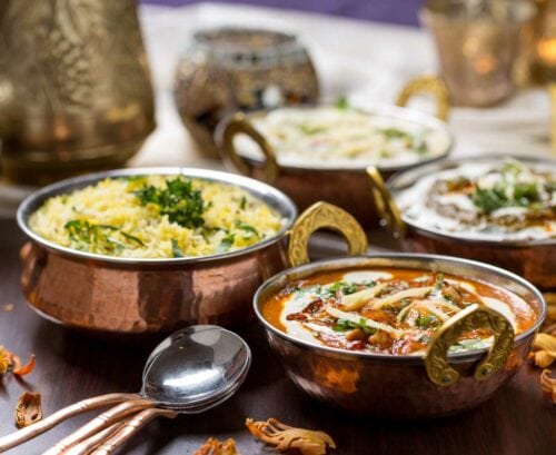 Indian curry and rice in copper dishes
