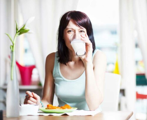 Woman drinking milk at the breakfast table