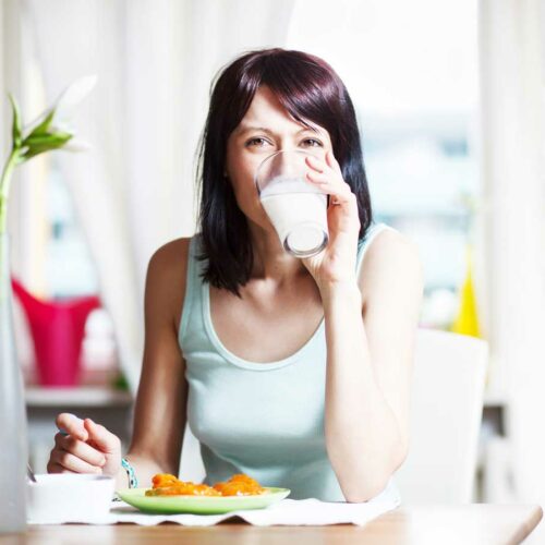 Woman drinking milk at the breakfast table