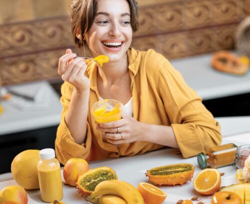 Laughing woman eating fruit puree